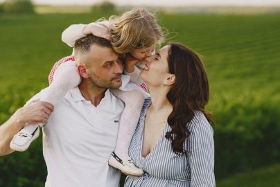 A delightful family moment captured in a lush scenic field, portraying love and happiness.