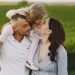 A delightful family moment captured in a lush scenic field, portraying love and happiness.