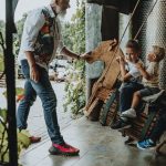 Adults interacting with children enjoying a playful moment indoors on swings.